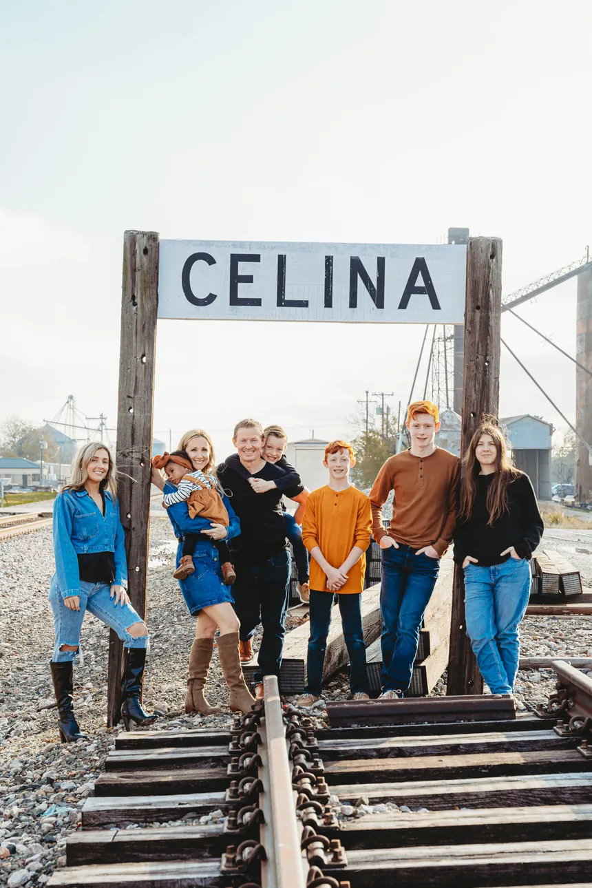 David Solomon with his wife and six children under the Celina, Texas railroad sign